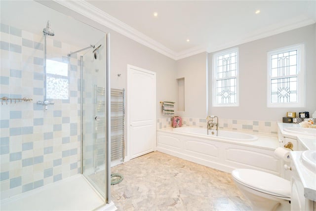 Twin wash basins and a walk-in shower are among the facilities in this plush bathroom.
