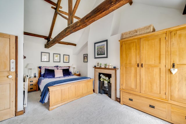 Open beams and a period fireplace add to the charm of this bedroom