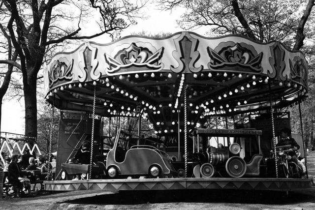 A small childrens carousel located near the Waterloo lake side car park at Roundhay Park. Run by the Miller family the ride consists of scaled down vehicles for children including a fire engine, a train, a motorcycle and two buses with notices reading 'Do Not Alight Until Bus Stops' on the rear and Miller's Tours, on the front. A sign shows the fare to be 6D,. The fairground was removed in the late 1990s.