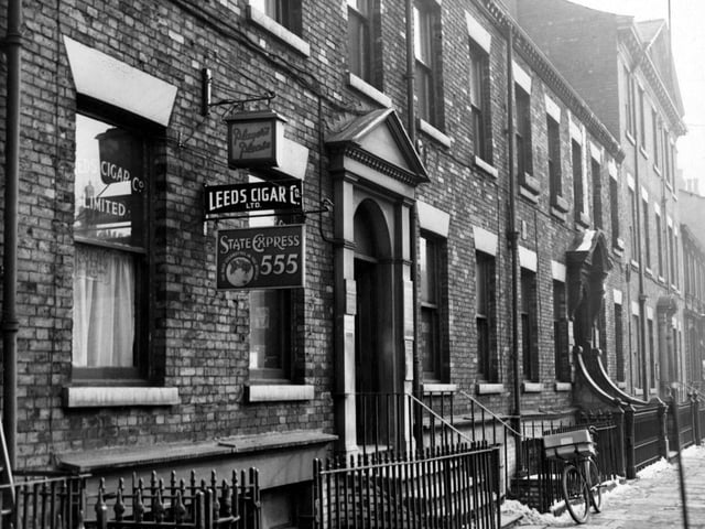 Looking south along Park Square showing Leeds Cigar Co. Ltd A bicycle leans against railings. Pictured in February 1955.