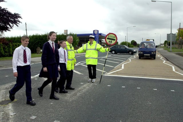 Jan Ramsay safely oversees the crossing of Garforth Community College pupils Thomas Spurr, Faye Hartley and James Allinson in June 2000. The pupils are pictured with  Mark Schofield, route manager for Leeds City Council's highways department.