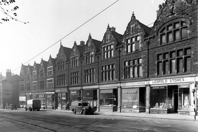 A view of the west side of Chapeltown Road in September 1949. Shops visible from left to right are Walkers removals; Ivrit restaurant; Dobkin's chemist; A. Rubin poultry dealers; Abram's butchers; Capel stores; Pooles confectioners; D. Flockton electrical repairs; Harris tailors; Margel poultry dealers; Waldenberg and Gorwits furnishers and Leopold Stores. Cars and tramlines are visible.