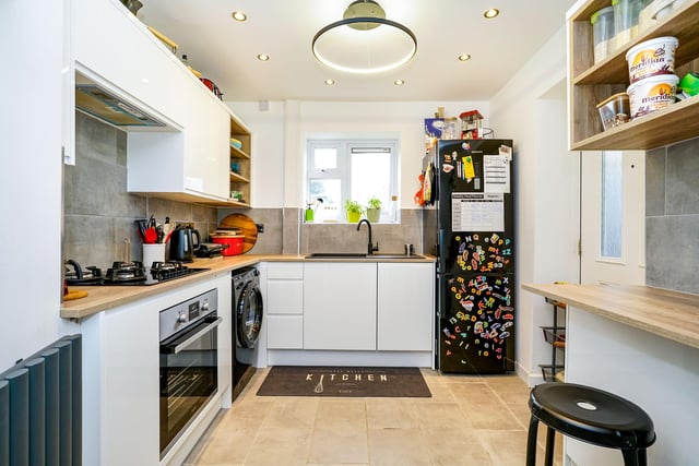 Downstairs, a spacious entrance hall with bespoke fitted storage units leads into the kitchen, which has a wine rack, dishwasher, fridge freezer and USB power sockets.