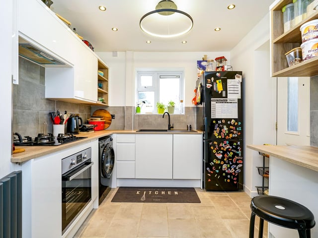Downstairs, a spacious entrance hall with bespoke fitted storage units leads into the kitchen, which has a wine rack, dishwasher, fridge freezer and USB power sockets.