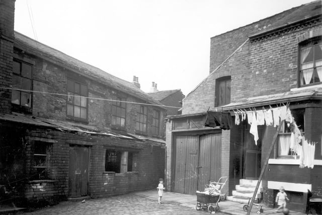 Children are playing with toys on Craven Street. To the left is the back of Nether Works, in the 1890s this had been a leather works. In 1963 it was being used to manufacture gaskets by James Dolman and Co Ltd.