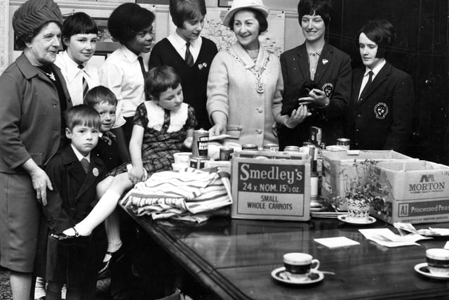 The Lady Mayoress of Leeds, wife of the Lord Mayor Joshua Walsh, is seen with a group of children looking at gifts of tins of etc. at a children's holiday camp gift day at Great George Street in April 1967.