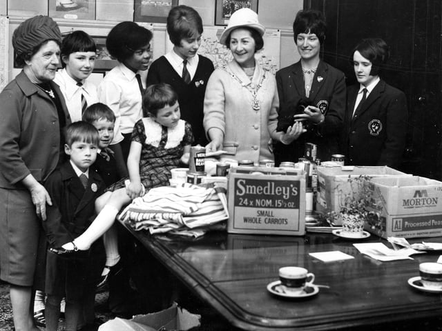 The Lady Mayoress of Leeds, wife of the Lord Mayor Joshua Walsh, is seen with a group of children looking at gifts of tins of etc. at a children's holiday camp gift day at Great George Street in April 1967.