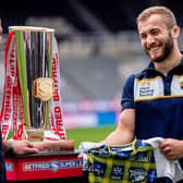Rhinos' Jarrod O'Connor at St James's Park with the Betfred Super League trophy and Doddie Weir tartan shirt Leeds will wear on Saturday. Picture by Alex Whitehead/SWpix.com.