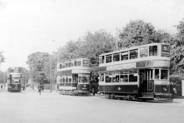 Three trams at the Roundhay Park tram stop on Princes Avenue in July 1934. The tram in the distance to the left is number 147. In the centre, tram number 394 is on route 4 with the destination shown as Kirkstall Abbey. Tram number 154 is to the right, this tram is travelling to Beeston on route 5 via Beeston Road. Trams are decorated with adverts for Melbourne Ales.