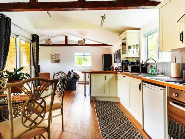 Inside there is a fridge with a small freezer compartment, a dishwasher, kettle, Tassimo coffee maker, microwave and a toaster in the kitchen area.