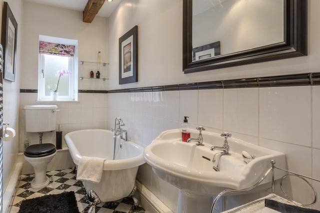 A period style bathroom with a deep, free standing bath tub.