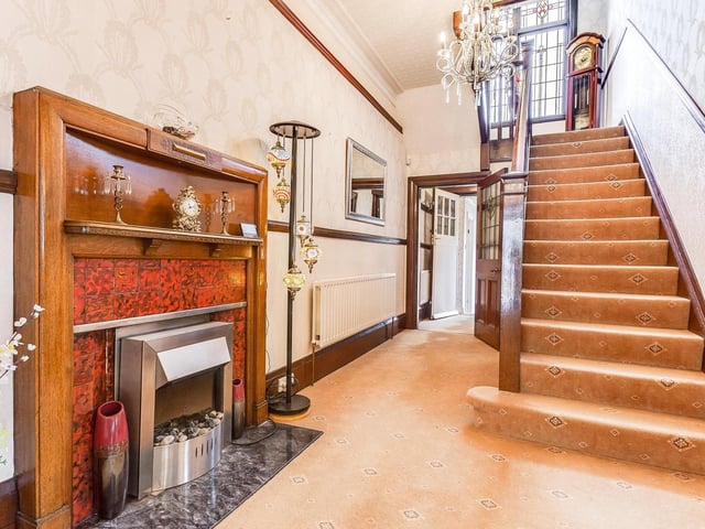 A large fireplace takes pride of place in this hallway, with staircase leading up to the upper two floors.