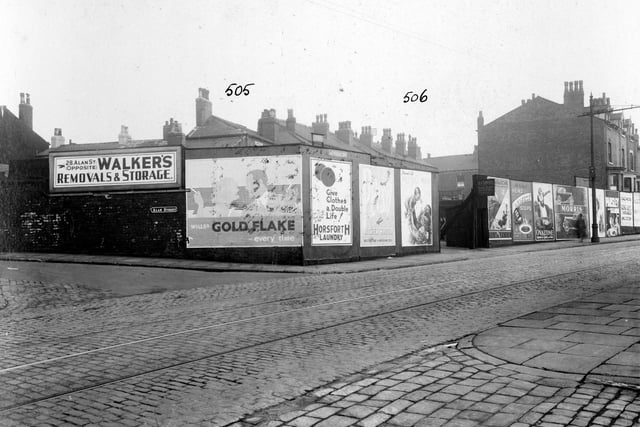 Stoney Rock Lane in September 1935. On the left is Alan Street, with a sign for 'Walkers Removals and Storage' 28 Alan Street. Advertising hoardings surround number 75, which is yard belonging to Mrs Emily Coates, dairy. Sign outside yard names it the 'Rock Dairy' selling milk. Product posters includes Wills's 'Gold Flake' cigarettes, Horsforth Laundry, Heinz Soup, Ovaltine and Morris Cars.