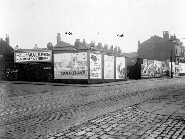 Stoney Rock Lane in September 1935. On the left is Alan Street, with a sign for 'Walkers Removals and Storage' 28 Alan Street. Advertising hoardings surround number 75, which is yard belonging to Mrs Emily Coates, dairy. Sign outside yard names it the 'Rock Dairy' selling milk. Product posters includes Wills's 'Gold Flake' cigarettes, Horsforth Laundry, Heinz Soup, Ovaltine and Morris Cars.