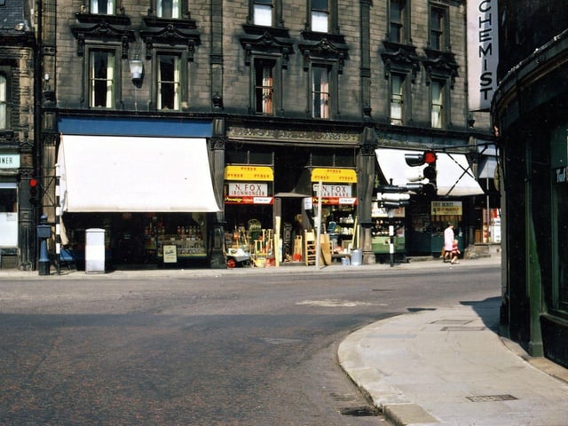 Cheapside, Morley Bottoms, looking directly past the traffic lights at the bottom of Scatcherd Hill. Some of the old Edwardian names still appear over two of the shops, but of the modern names only that of Norman Fox, the ironmonger, is easy to distinguish. Pictured in August 1967.