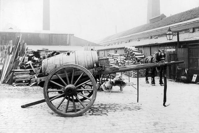 Black Bull Yard, the Leeds Corporation Sewage Yard located at 22 Black Bull Street. In the foreground is a flush cart used for flushing out sewers. Various materials are piled up in the background and a horse can be seen on the right. Pictured in July 1902.