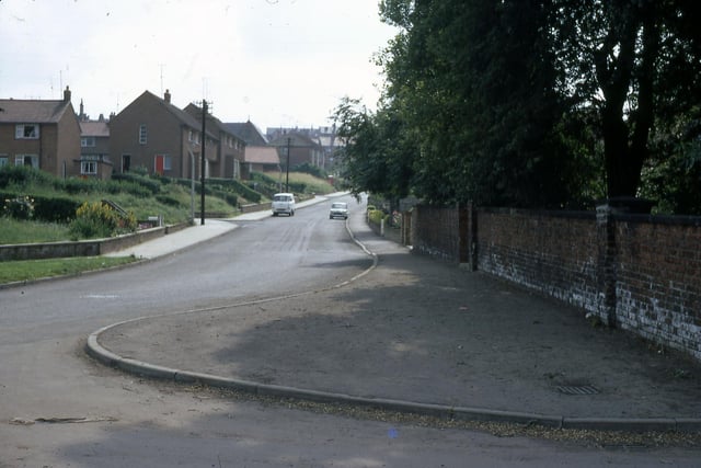 Old Road at Manor Farm looking towards Churwell Primary School in July 1968. Manor Farm is on the near right, and the old primary school can just be seen above the houses. The houses are part of the Manor Road Council estate.