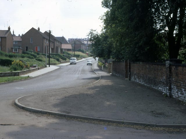 Old Road at Manor Farm looking towards Churwell Primary School in July 1968. Manor Farm is on the near right, and the old primary school can just be seen above the houses. The houses are part of the Manor Road Council estate.