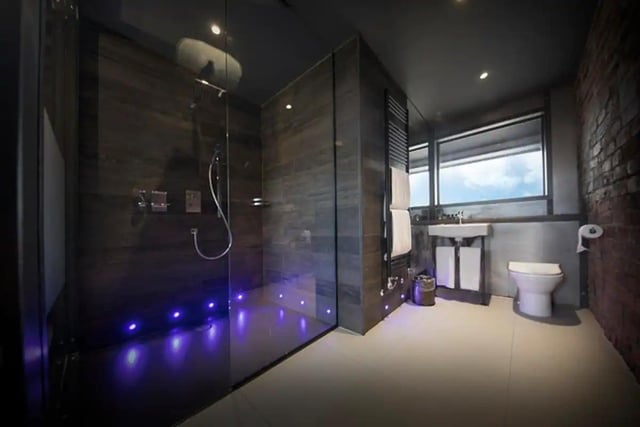 The bathroom has a beautiful walk-in shower with LED lights.