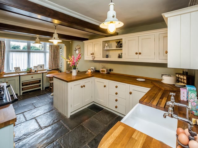 The beamed kitchen has fitted units, with a gas Aga, an integrated dishwasher, and under floor heating, with windows at both front and rear.