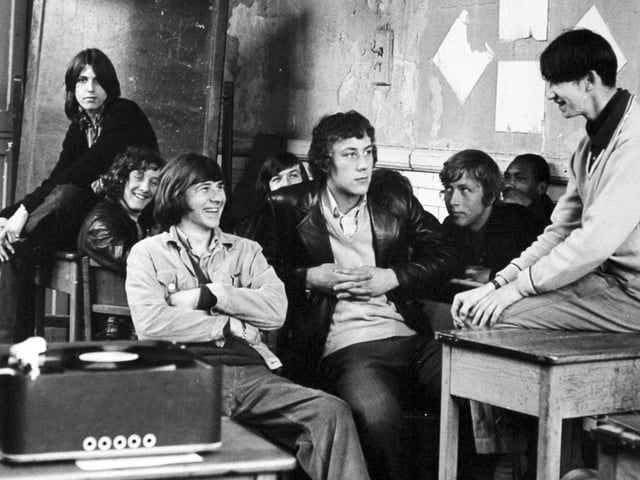 A class of students at Kitson College listen to a record during a general studies period in a classroom with paint and plaster peeling from the walls in June 1971.