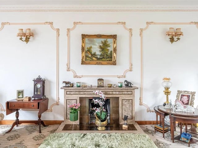Progressing further into the property, this delightful home begins to provide a glimpse of the space on offer. A formal living room displays a traditional fireplace.
