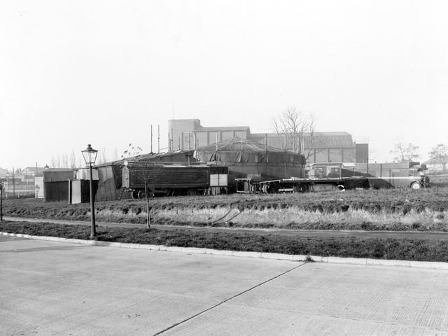 A section of the ring road pictured in October 1941. In the background is a fairground roundabout covered in tarpaulin. A caravan is parked next to it. The fair is on the site of the current Red Lion public house, formerly known as the Traveller's Rest. Soon after the Second World War the land housed a day nursery, prior to the building of the Traveller's Rest. The building at the back is the Regal Cinema, which opened in November 1936 and closed in January 1964.