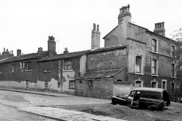 On the left of this view, the backs of houses on Barnet Square can be seen. View looks from Strawberry Road. On the right edge is number 12 Barnet Mount, an old building which had originally been known as Southfield House. Occupants of this house in 1861 were trading as Brown and Rhodes Brothers. In the foreground an abandoned car can be seen. Pictured in May 1965.