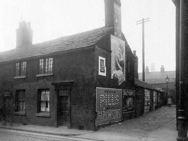 The cobbled entrance to Taylor's Place taken from Low Road in August 1929. Painted advertising signs to gable end of house, most prominent are Sunlight Soap, Parkinsons pills and Palethorpes.