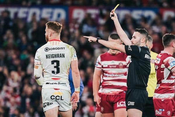Catalans’ Adam Keighran is shown a yellow card by referee Liam Moore after a dangerous throw on Wigan’s Kai Pearce-Paul. Picture by Alex Whitehead/SWpix.com.