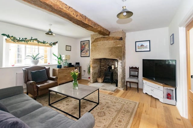 The living room features traditional exposed oak beams and a feature fireplace with window to front aspect.