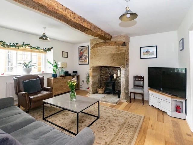 The living room features traditional exposed oak beams and a feature fireplace with window to front aspect.