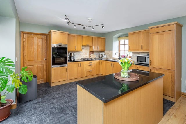 This wonderful home offers a spacious open plan kitchen and diner fitted with a range of modern base and eye level units, and a kitchen island cupboard with contrasting worktops.