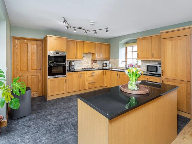 This wonderful home offers a spacious open plan kitchen and diner fitted with a range of modern base and eye level units, and a kitchen island cupboard with contrasting worktops.