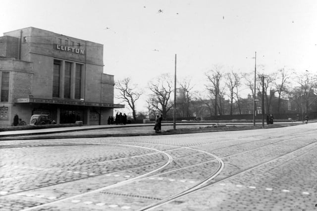 The Clifton Cinema on Stanningley Road in March 1939. In front of the cinema is a man with a bicycle, a car and groups of people.