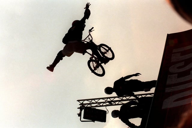 A BMX bike carries out a quarter pipe move to entertain revellers.