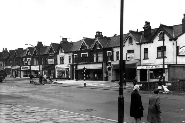 A view from Harehills Corner (the junction of Roundhay Road and Harehills Lane) showing a row of shops on Roundhay Road in June 1966 numbered (from left) 271 to 291. These include John Gilpin Ltd., bakers and confectioners at no.277, Crockatt's cleaning at 279, Ainley (Leeds) Ltd., electrical engineers 281, Doreen Ladies' Fashions 283 and the Leeds and Holbeck Building Society on the corner at no.291.