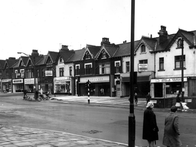 A view from Harehills Corner (the junction of Roundhay Road and Harehills Lane) showing a row of shops on Roundhay Road in June 1966 numbered (from left) 271 to 291. These include John Gilpin Ltd., bakers and confectioners at no.277, Crockatt's cleaning at 279, Ainley (Leeds) Ltd., electrical engineers 281, Doreen Ladies' Fashions 283 and the Leeds and Holbeck Building Society on the corner at no.291.