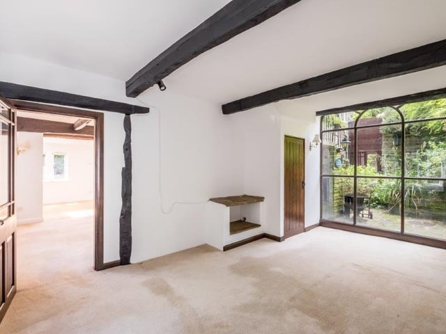 Ceiling beams and a window wall in this room add to the light and warmth of the interior.