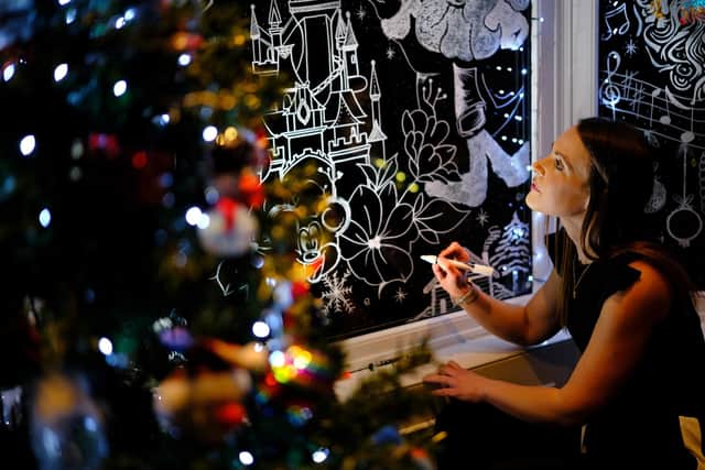 Alyssa Spivey works on her Christmas window art (Credit: Richard Ponter)