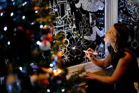 Alyssa Spivey works on her Christmas window art (Credit: Richard Ponter)