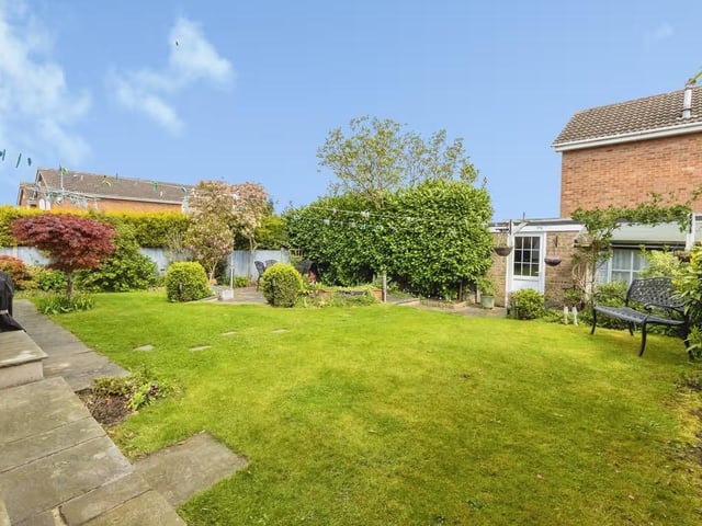 Outside, the landscaped rear garden has lawn and patio areas, established planting, a summerhouse and useful storage, with outdoor power and water.