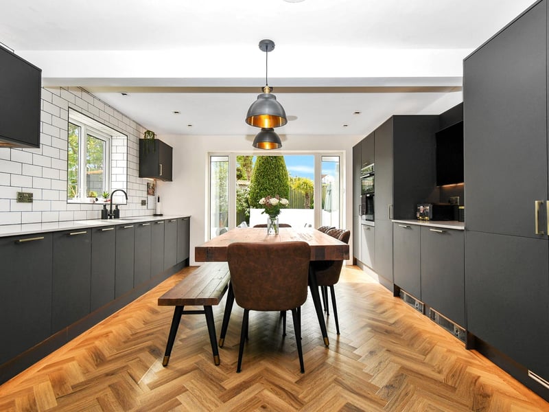 The property boasts open plan living spaces, including this stunning dining kitchen with French doors leading to the back garden.