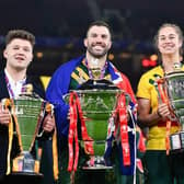 England's Tom Halliwell with Australia's James Tedesco and Kezie Apps show off the wheelchair, men's and women's World Cup Trophies at the end of last year's tournament. Picture by Will Palmer/SWpix.com.
