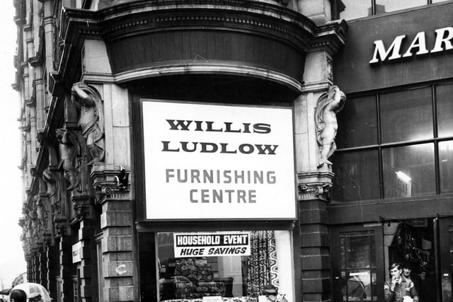 The entrance to Kirkgate Market on the corner of Vicar Lane and Ludgate Hill. In the centre is a shop window of the furnishing department of Willis Ludlow department store, displaying sofas and chairs and advertising 'huge savings'. Pictured in January 1979.