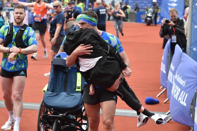 Kevin Sinfield carries his former teammate over the finish line of the 2023 Rob Burrow Leeds Marathon at AMT Headingley last May. Picture by Matthew Merrick/Leeds Rhinos.
