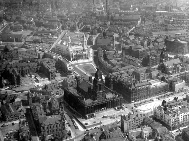 An aerial view of the city centre including Leeds Civic Hall and Leeds Town Hall. In the centre of the left edge the Gothic Revival style frontage of Leeds General Infirmary can be seen, facing onto Great George Street. Continuing right, the Leeds Institute is visible, recognisable by the roof of its centrally positioned circular lecture hall. The block of properties which follow to the left of this development are the Municipal Buildings (1884). These buildings originally housed civic offices along with Leeds Central Library.