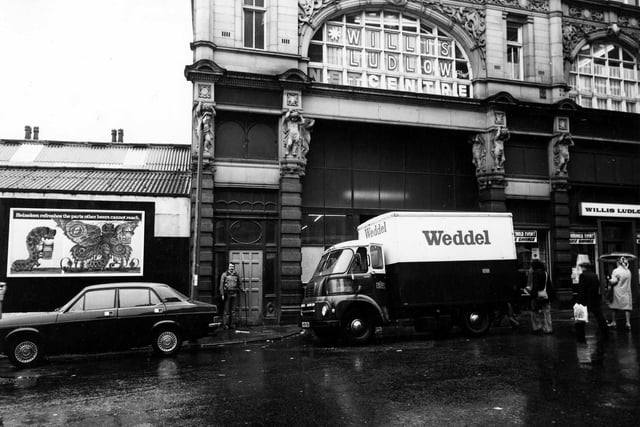 Looking from Ludgate Hill to the side entrance to Kirkgate Market, which is blocked from view by a lorry with the name 'Weddel' on the side. Willis Ludlow department store, is on the right and on the upper floor above the entrance. On the left there is an advertising hoarding for Heineken beer. Pictured in January 1979.