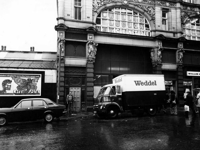 Looking from Ludgate Hill to the side entrance to Kirkgate Market, which is blocked from view by a lorry with the name 'Weddel' on the side. Willis Ludlow department store, is on the right and on the upper floor above the entrance. On the left there is an advertising hoarding for Heineken beer. Pictured in January 1979.