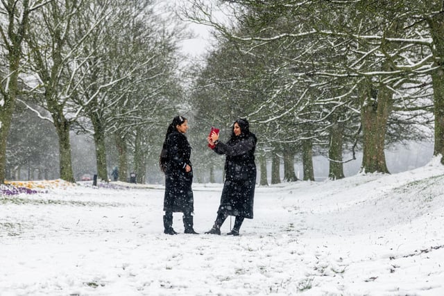 Pictured (right) Aneela Habib, takes a picture of her daugther Shiza Qamar on the snow covered Soldiers Field in Leeds.